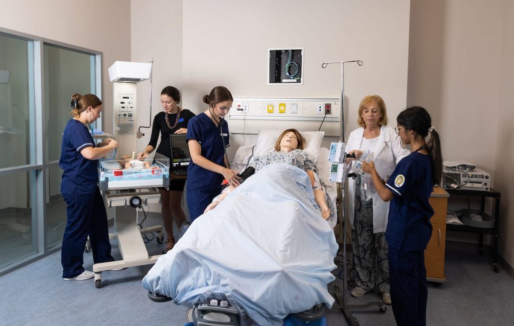 nursing students working around a patient bed