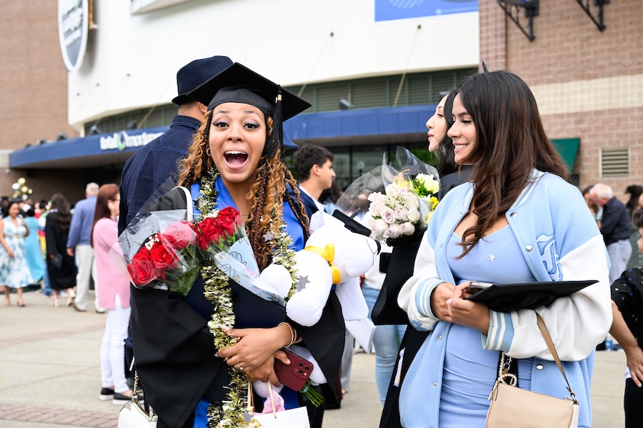 A happy graduate holding flowers